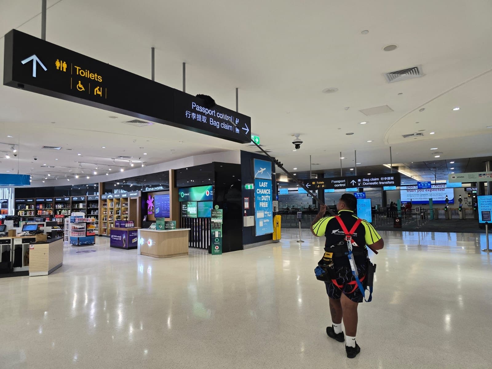 A KMG crew member crossing an airport terminal in harness while the terminal stays open around him